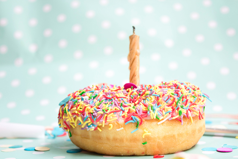 birthday doughnut with sprinkles and a candle